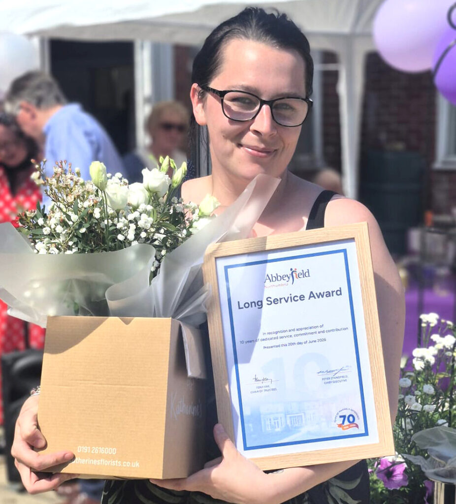 A colleague holding a long-service certificate