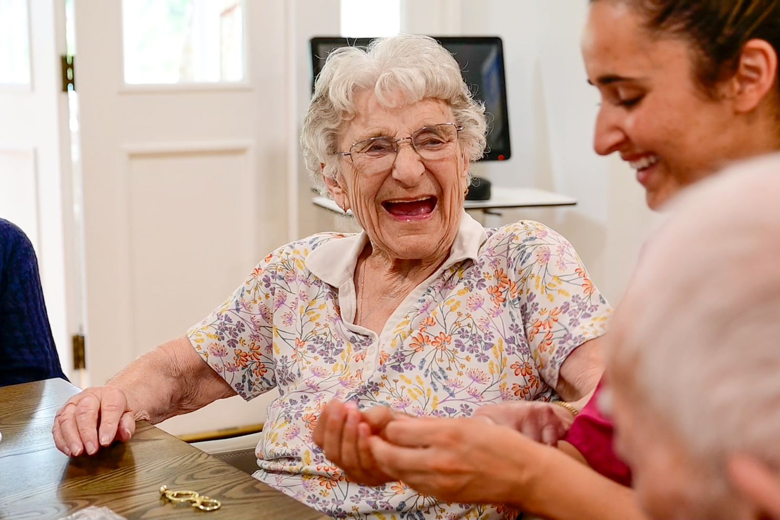 A smiling resident enjoying time together around a table