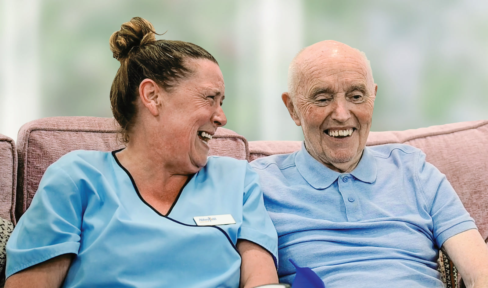 A care team member and a resident sharing a laugh