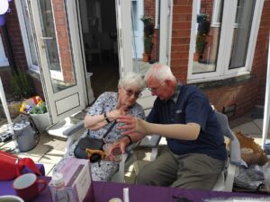 A man leaning towards a seated woman for a close conversation outside The Grove.
